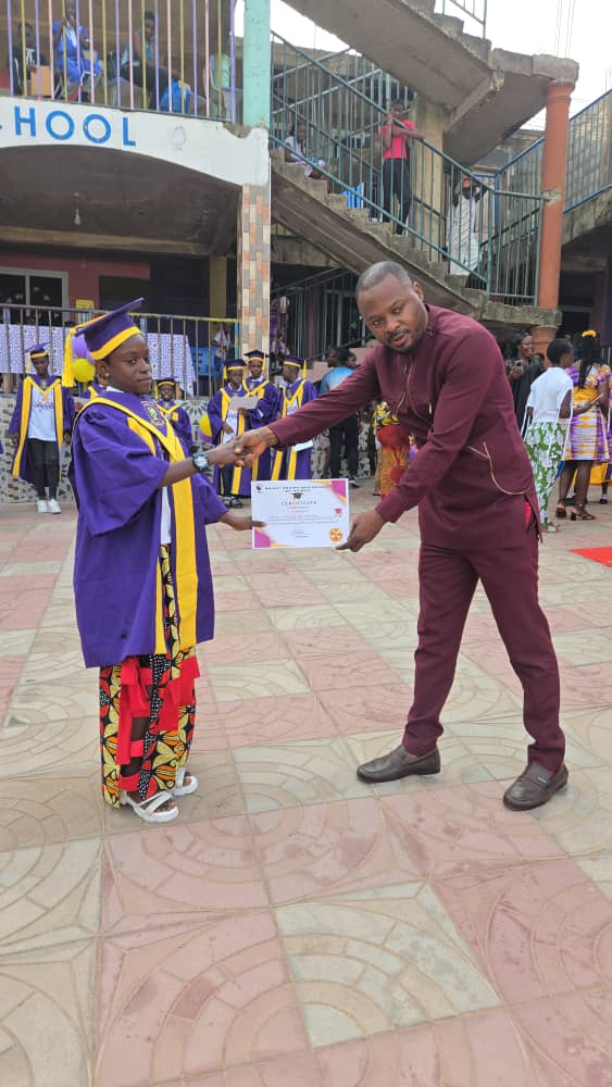 A graduating pupil receiving an award certificate on the red carpet