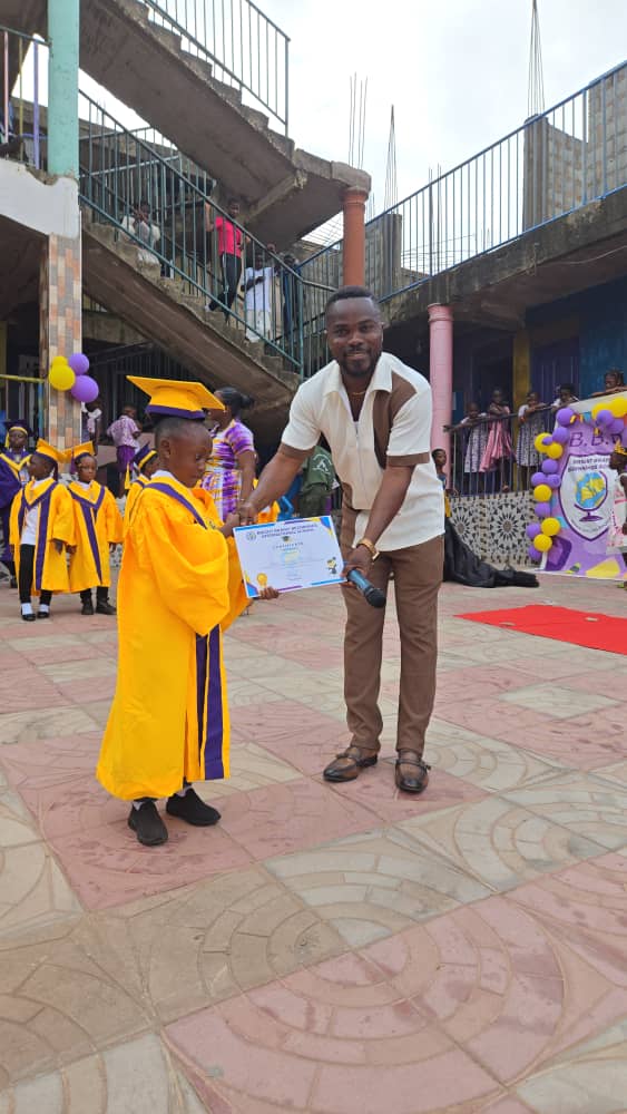 A BBBIS graduate receiving a certificate from the headmaster